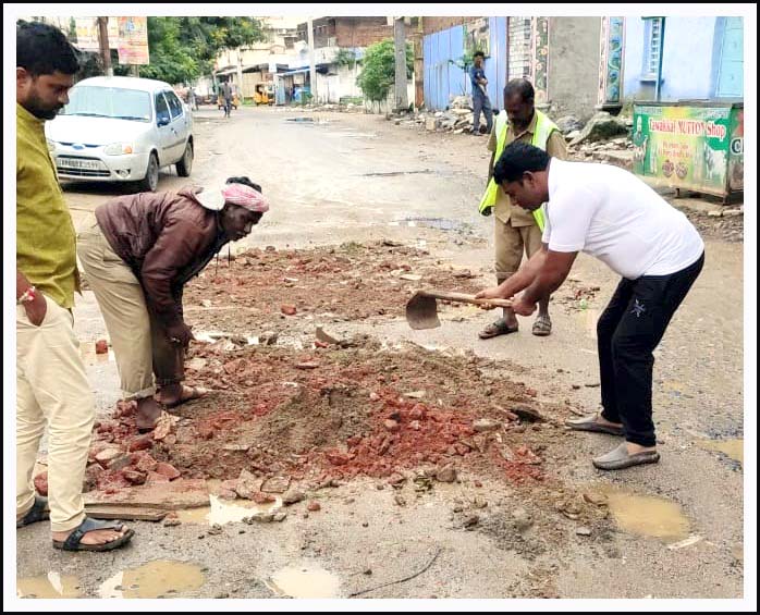 రోడ్డుపై గుంత‌లు పూడ్చిన కౌన్సిల‌ర్
