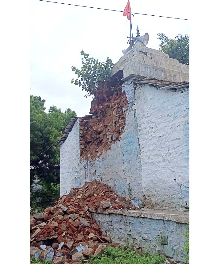 వ‌ర్షానికి కూలిన దేవుని గుడి గోడ‌